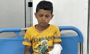 A Palestinian child, wounded in an Israeli strike on an area designated for displaced people, sits at a hospital in Rafah in the southern Gaza Strip on May 26. — Reuters