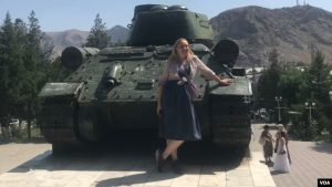 A tourist poses in front of the World War II-era T-34 Soviet tank in Aravan, Osh province, July 7, 2024.